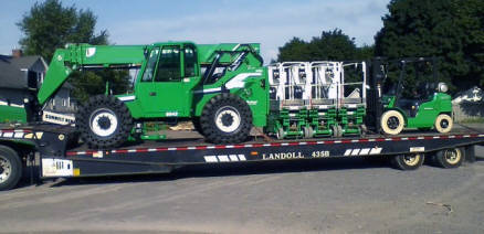 Heavy duty flatbed Landoll trailer loaded with heavy equipment