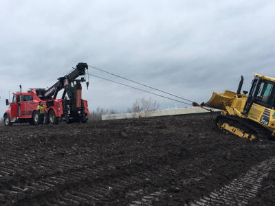 Picture of Kerhaert's 50 ton wrecker winching out a bulldozer stuck in mud.