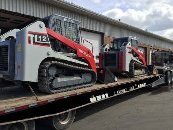 Kerhaert's Landoll flatbed trailer hauling two skid steers.