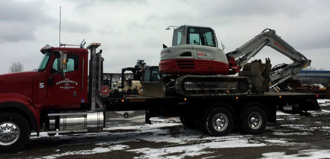 Picture of our new 10 wheel heavy duty flatbed hauling a mini excavator
